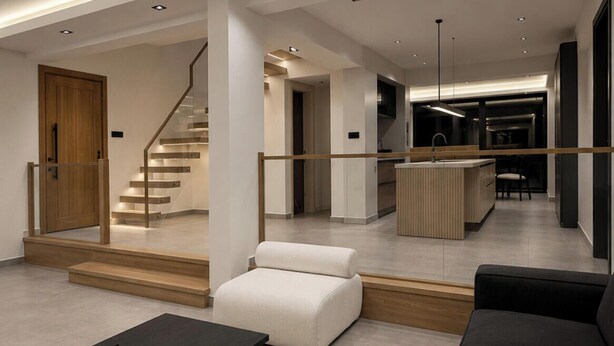 A modern interior with a staircase, a sofa, a coffee table, and a kitchen area. - Luxury Renovated New Villa in the heart of Kalkan (ANTALYA)