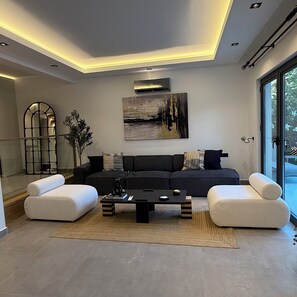A modern living room with a sectional sofa, a coffee table, and a large window.