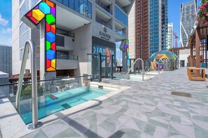 A modern hotel with a swimming pool, outdoor seating, and a Dayclub sign. - Velvet Miami Pool & Gym (Miami)