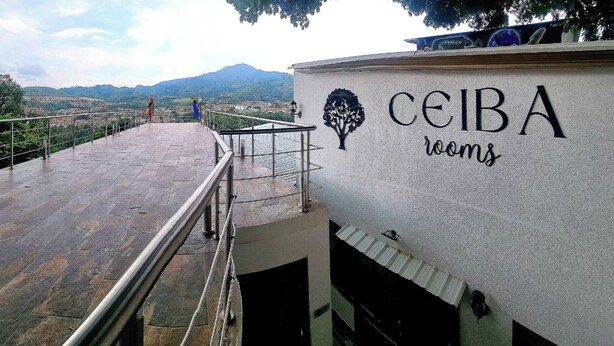 Un hotel chiamato 'CEIBA rooms' con vista sulla città e sulle montagne sullo sfondo.