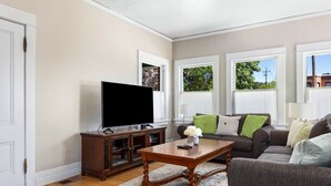 A living room with a television, wooden cabinet, and a sofa. - Blue Chestnut-Westside Paso Getaway (Paso Robles)