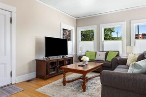 A living room with a television, wooden cabinet, and a sofa. - Blue Chestnut-Westside Paso Getaway (Paso Robles)