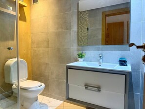 Ein modernes Badezimmer mit Toilette, Waschbecken und Spiegel.