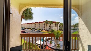 A balcony with a view of a parking lot and a building with red roofs. - Coastal St. Augustine Beach Condo | Partial Ocean View | Resort Amenities | Steps to the Beach | Sleeps 6 (St. Augustine)