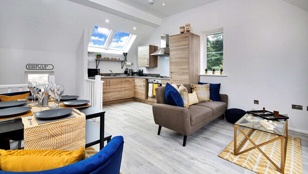 A modern living space with a dining area, a sofa, and a kitchen. - Holiday Home Near Centre of Whitby (Whitby)
