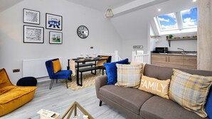 A modern living room with a sofa, chairs, a dining table, and artwork on the walls. - Holiday Home Near Centre of Whitby (Whitby)