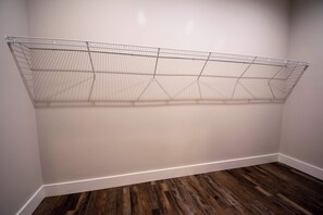 A room with a wire shelving unit against the wall and a wooden floor. - Modern Upper Retreat II | 2 Suites + Free Tix (Hendersonville)