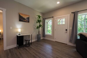 A room with a desk, chair, potted plant, and a door with windows. - Druid Hills Retreat II | Sleeps 8 | Free Tix (Hendersonville)