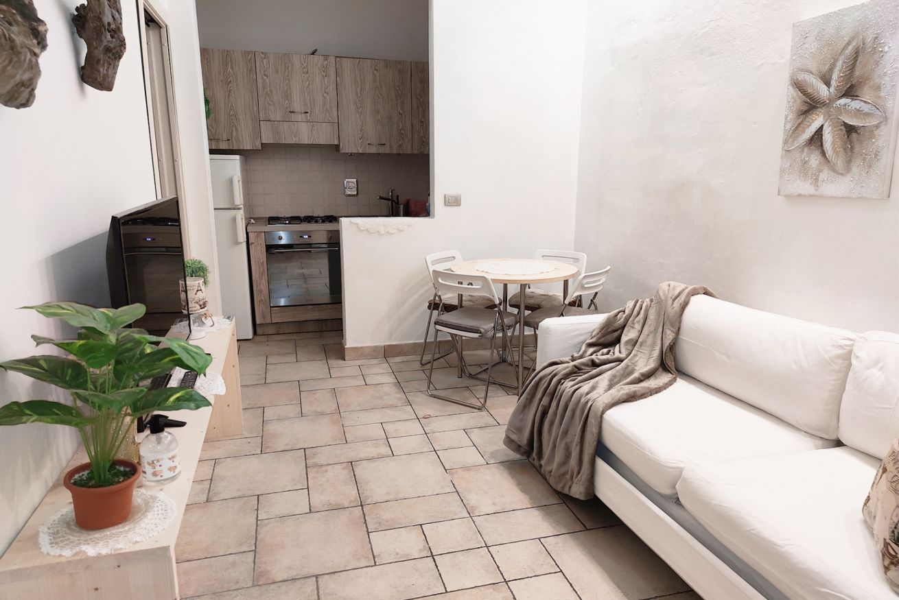 A compact living space with a kitchenette, a dining area, and a sofa.
