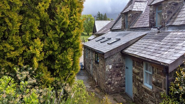 A stone building with a sloped roof, a chimney, and a small window. - Scenic Dales Hut With Hot Tub for 2 (Dolgellau)