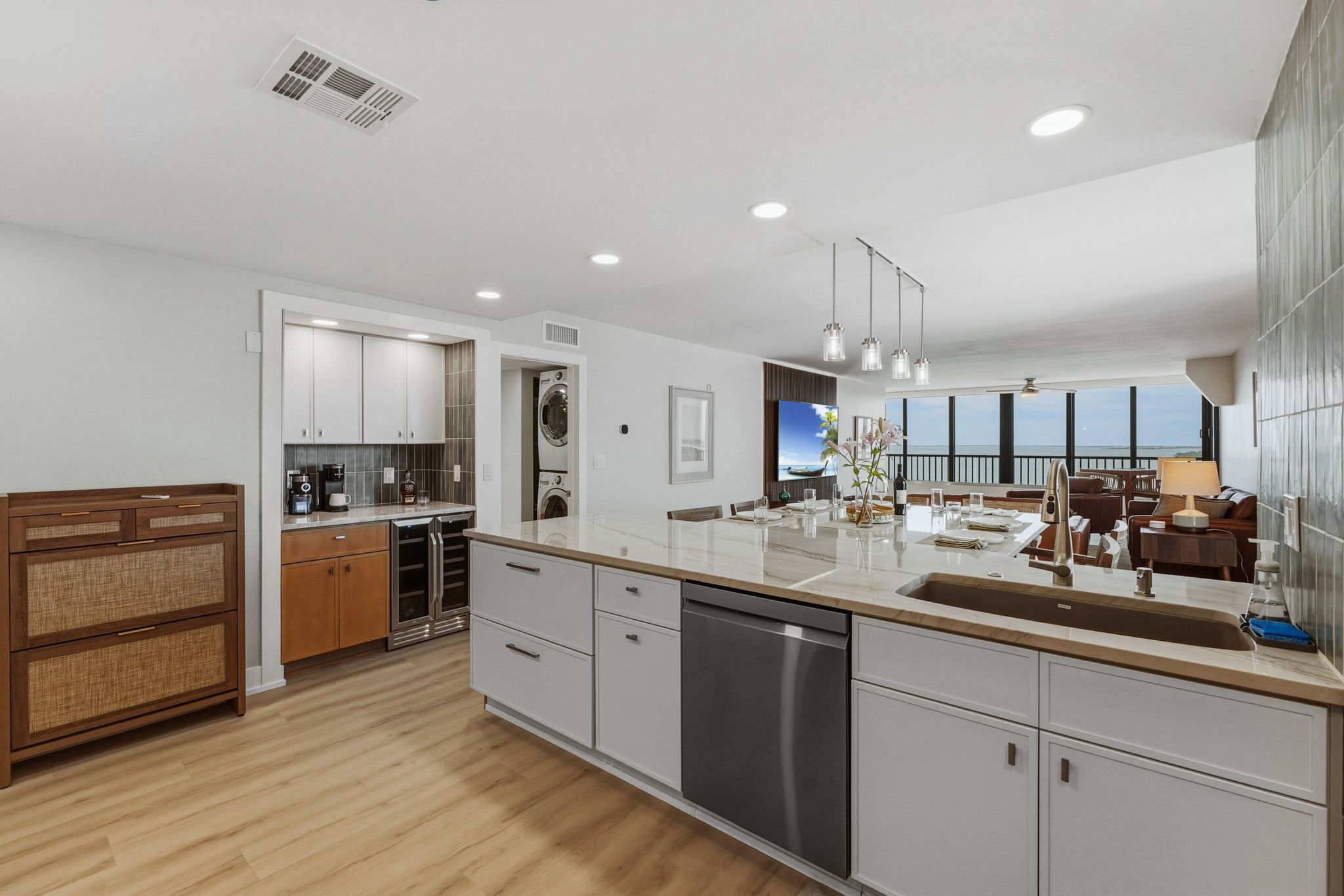 Una cocina moderna con una isla central, electrodomésticos integrados y un comedor con vistas.