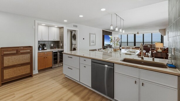A modern kitchen with a central island, built-in appliances, and a dining area with a view. - Punta Rassa Luxe Waterfront w/ Panoramic Views, Gorgeous Sunsets, Pool, Hot Tub (Fort Myers)
