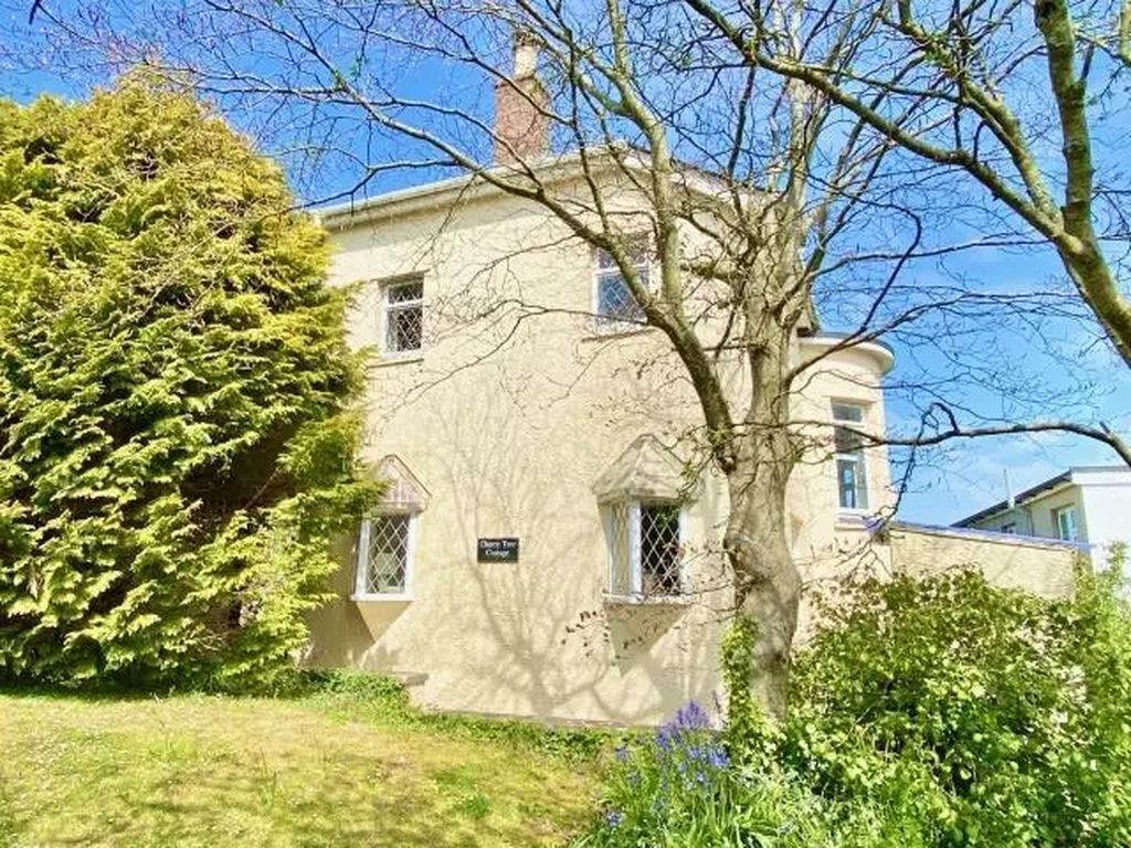 A two-story building with a stone facade, a small window, and a sign that reads 'Chateau de la Tour.'