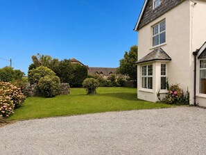 A residential property with a well-maintained lawn, a gravel driveway, and a variety of shrubs and flowers. - Broad Park-Sleeps 11 in 6 Bedrooms (Rock)