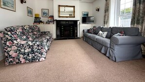 A living room with a fireplace, two sofas, and a television. - Broad Park-Sleeps 11 in 6 Bedrooms (Rock)
