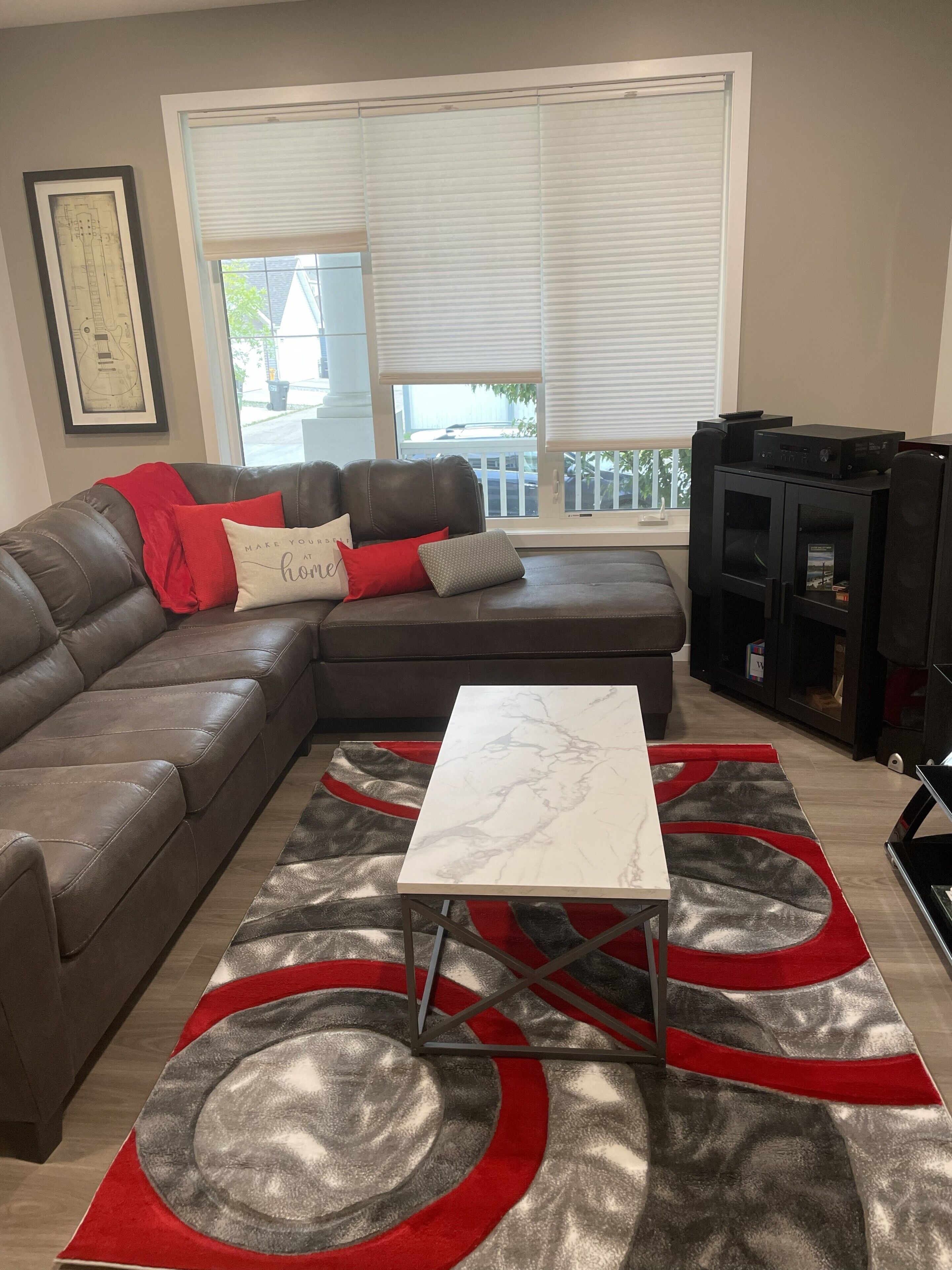 A living room with a sectional sofa, a coffee table, and a fireplace.