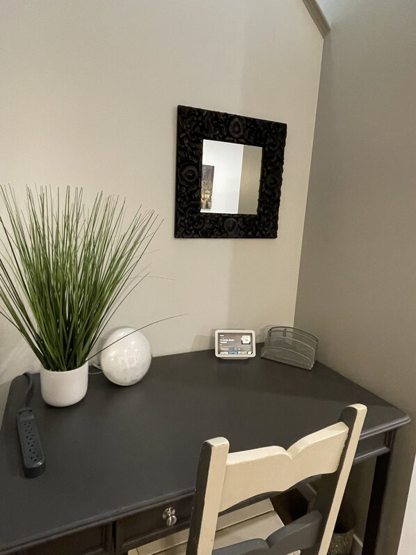 A desk with a potted plant, a vase, a clock, and a framed mirror on the wall. - summer side lake back yard BBQ pet friendly. (Edmonton)