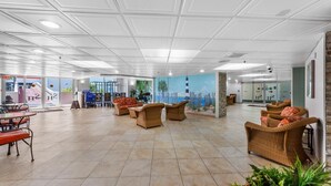 A spacious lobby with tiled flooring, wicker furniture, and a mural of a beach scene. - S Hampton 706 2 Br Oceanview in Kingston, Pool (Myrtle Beach)