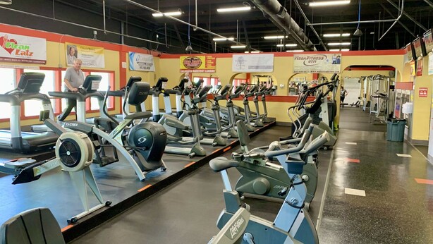 A gym with multiple treadmills and exercise equipment, a clean floor, and various signs on the walls. - S Hampton 706 2 Br Oceanview in Kingston, Pool (Myrtle Beach)