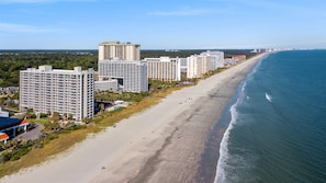 Eine Küstenstadt mit Hochhotels entlang eines Sandstrandes.
