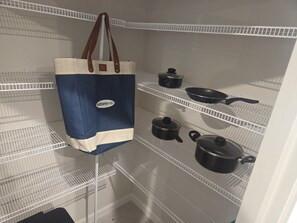 A storage area with shelves holding kitchenware and a mattyhomes tote bag.