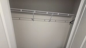 Un placard avec une étagère en fil de fer et un sol recouvert de moquette.