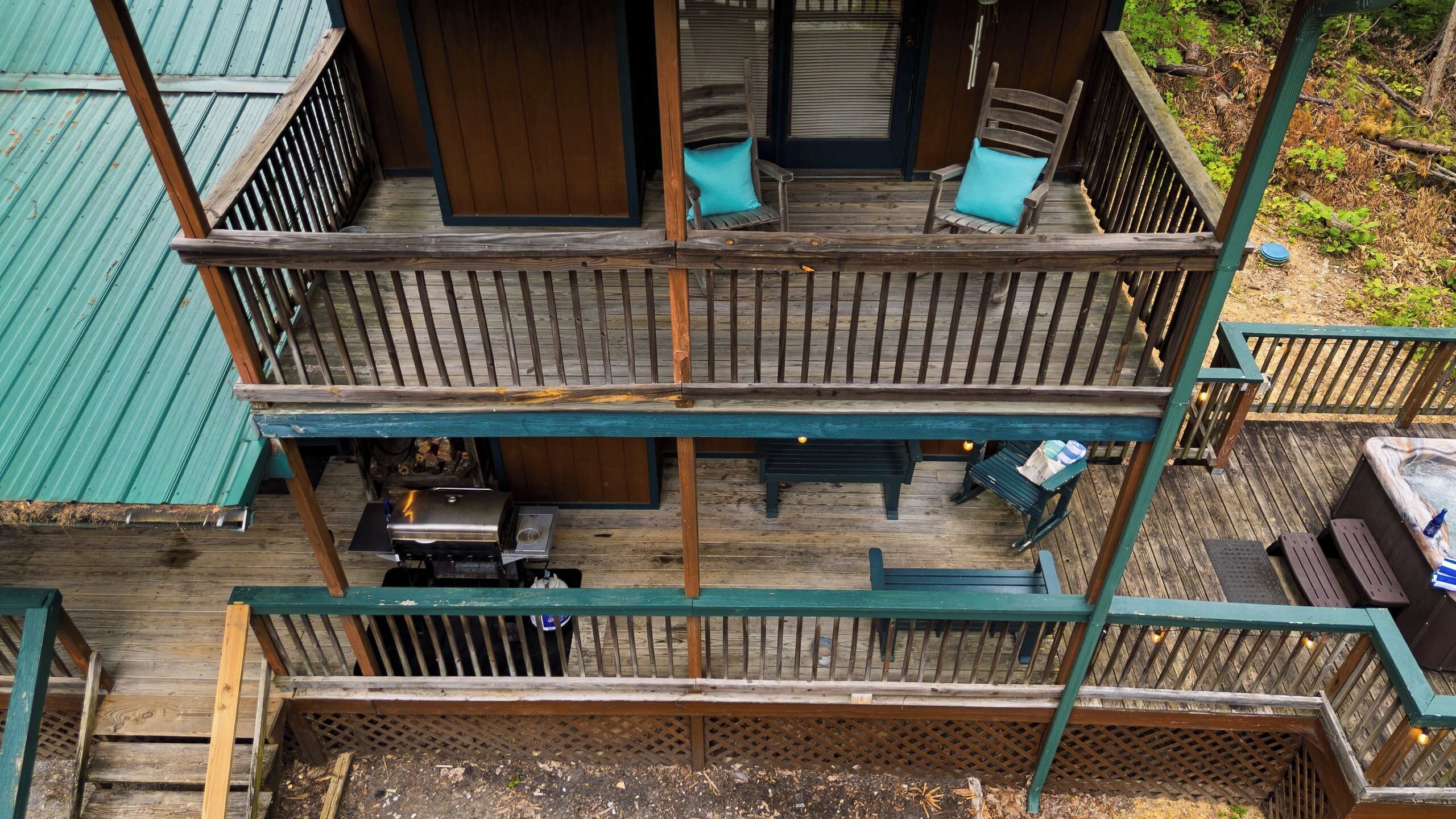 A multi-level wooden deck with outdoor seating and a grill area.