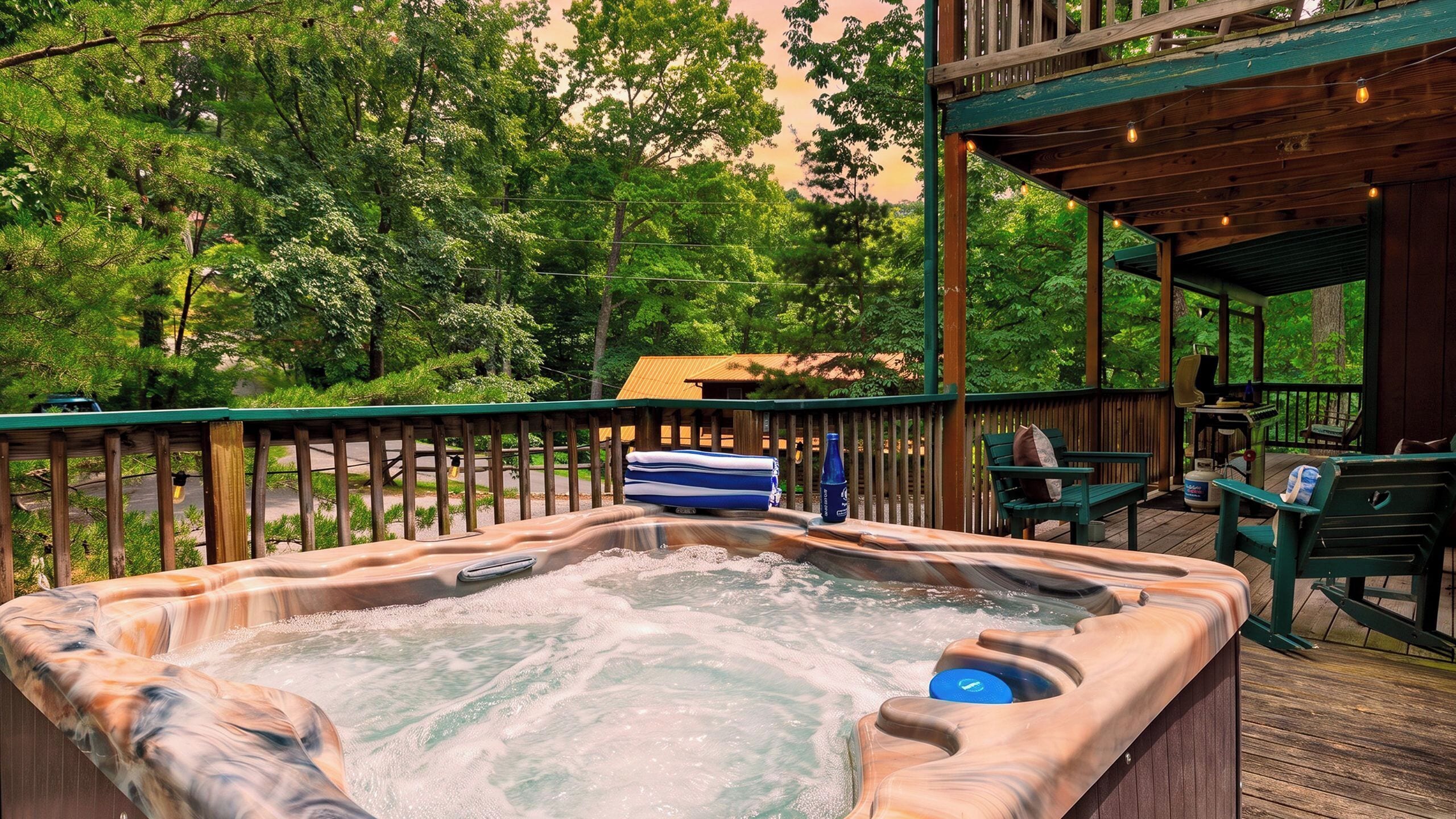 Un jacuzzi en una terraza de madera con vistas a árboles y un edificio al fondo.