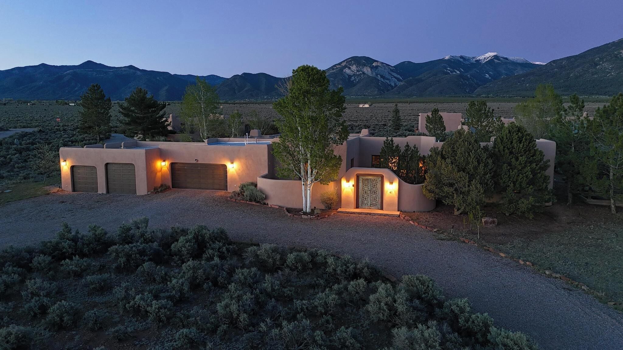 A modern house with a garage, a covered entryway, and a well-maintained garden.