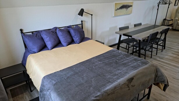 Ein Zimmer mit einem Bett, einem Schreibtisch und einem Stuhl.