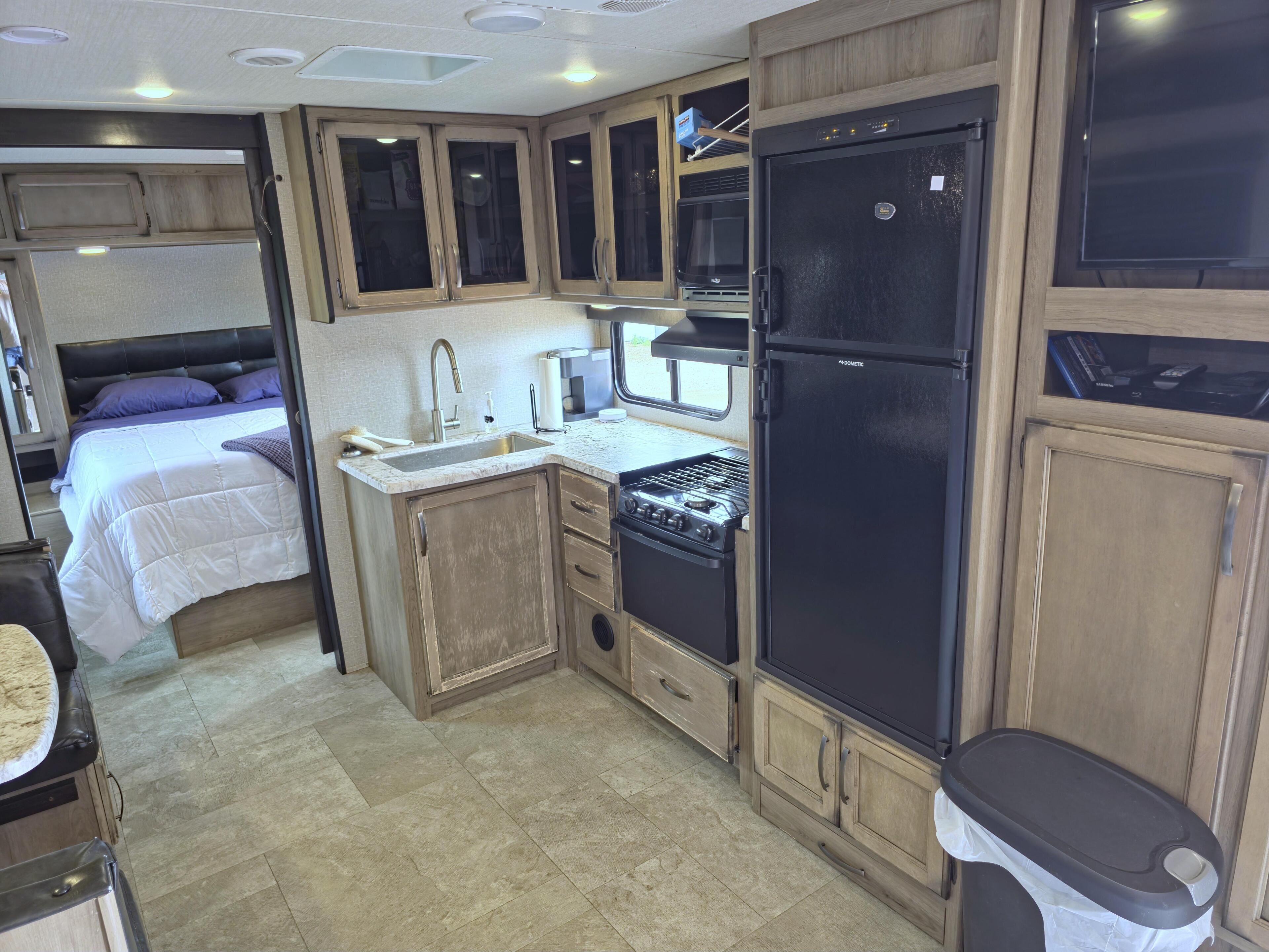 Cocina compacta para autocaravana con estufa, lavabo y refrigerador.
