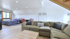 Uma sala moderna com sofá, mesa de jantar e cama.
