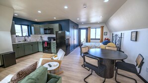 Um espaço compacto com cozinha compacta, área de jantar e quarto.