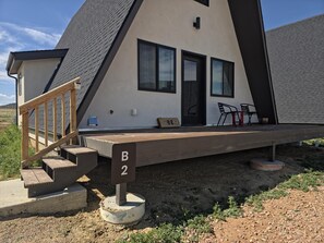 A modern house with a wooden deck, a staircase, and a door marked 'B2'.