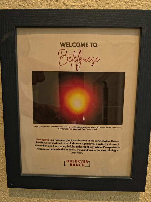 A framed welcome sign with a photograph of Betelgeuse, a red supergiant star.