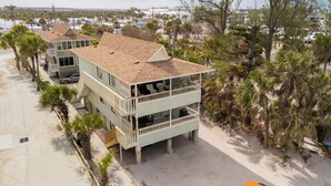 A beachfront property with a two-story building, a balcony on the upper floor, and a sandy beach in the background. - Paradise on the Sea (Englewood)