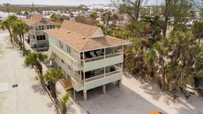 A beachfront property with a two-story building, a balcony on the upper floor, and a sandy beach in the background. - Paradise on the Sea (Englewood)