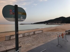 A beach with a sign indicating Praia do Ouro and Yes Sémbra Portugal. - Sail guest house (Sesimbra)
