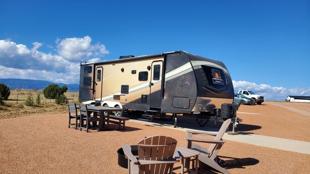 Una caravana o vehículo recreativo con cocina, una mesa de comedor y dos sillas.
