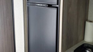 Una cocina con un refrigerador negro, un microondas y una estufa.