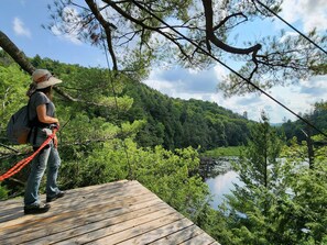 A wooden platform overlooking a river with dense forest in the background. - Cozy stay at Haliburton Forest. Trails, Wolf Centre, Canopy Tour, 100 lakes! (Dysart and Others)
