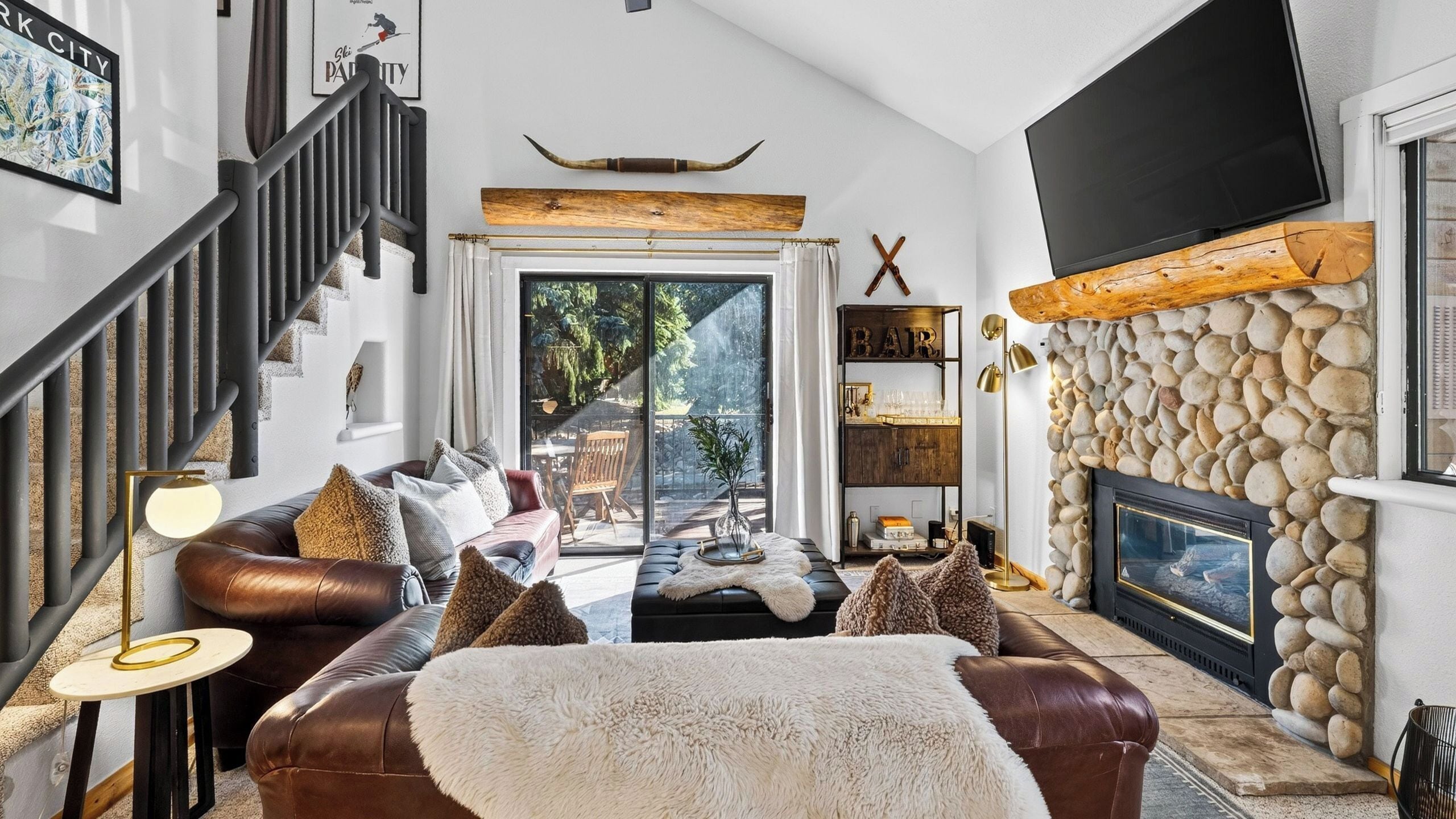 Ein modernes Wohnzimmer mit Ledersofa, Kamin und Steinwand.