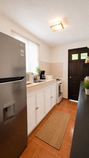 A compact kitchen with a refrigerator, a coffee maker, and a sink. - Private 2-bedroom apartment in the heart of Cancun (pet-friendly) (Cancún)