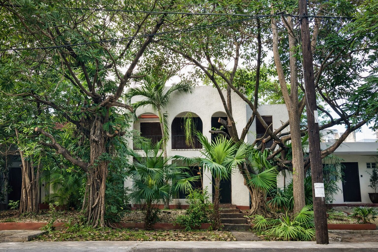 A building with a white facade, arched windows, and a staircase leading to the entrance.