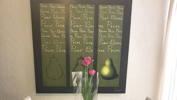 A dining table with a glass top, surrounded by white chairs, and a chalkboard with text and images of pears and tulips. - Private 2-bedroom apartment in the heart of Cancun (pet-friendly) (Cancún)
