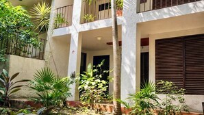 A multi-story building with balconies, surrounded by various plants and trees. - Private 2-bedroom apartment in the heart of Cancun (pet-friendly) (Cancún)
