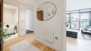 En moderne lejlighed med et stort vindue, en radiator og et spejl på væggen.