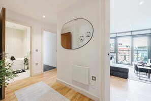 Un apartamento moderno con un ventanal grande, un radiador y un espejo en la pared.