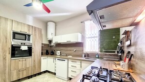 Eine moderne Küche mit integrierten Geräten, einem Gasherd und einem Fenster mit Vorhängen.