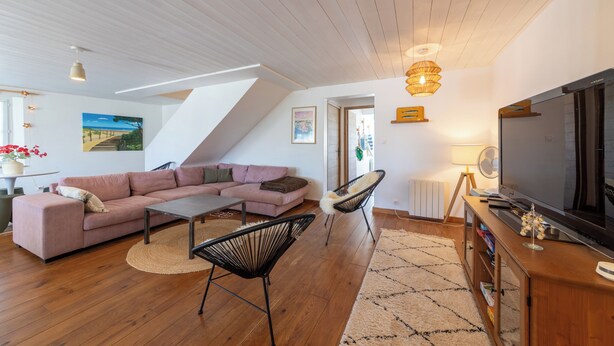 A modern living room with a sofa, a coffee table, a chair, a TV, and a fireplace. - Villa Insula - Proche plage - Jardin (Les Portes-en-Ré)